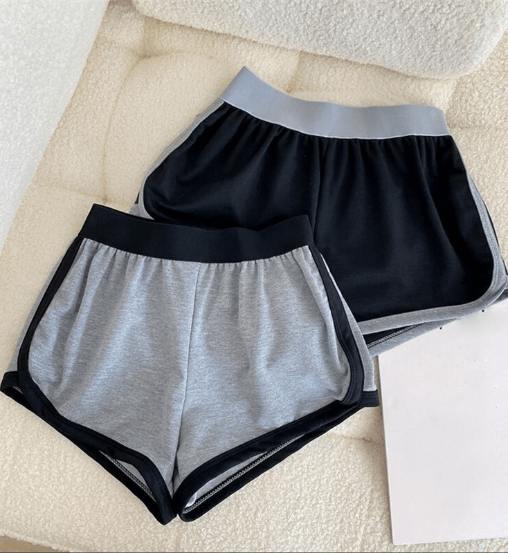 Two pairs of loose short women's sports shorts with elastic waistband, in black and gray, made from lightweight polyester.